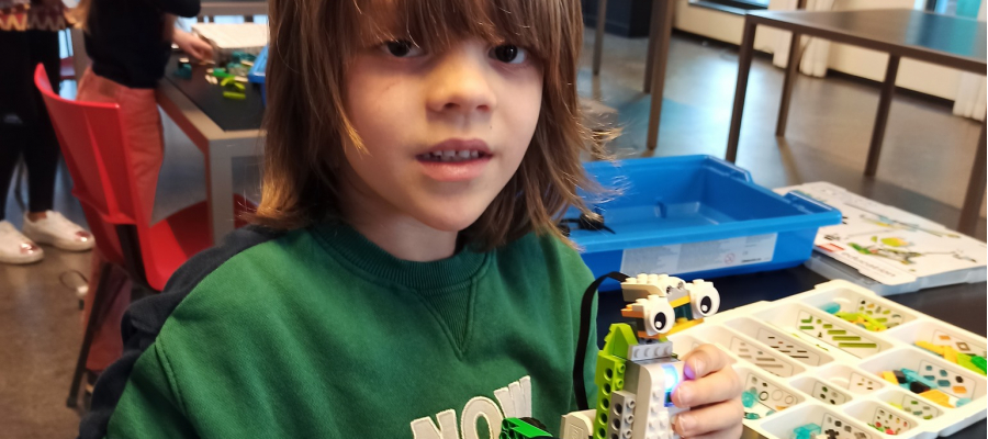Jongen toont trots de LEGO-robot die hij heeft gemaakt