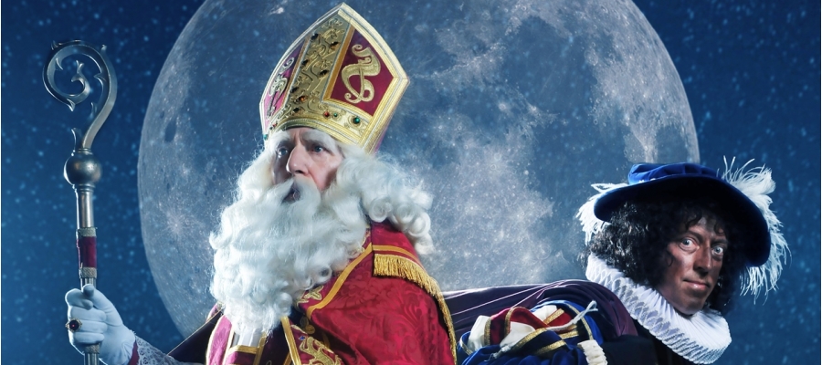 Sinterklaas en Zwarte Piet staan rug-aan-rug voor een volle maan