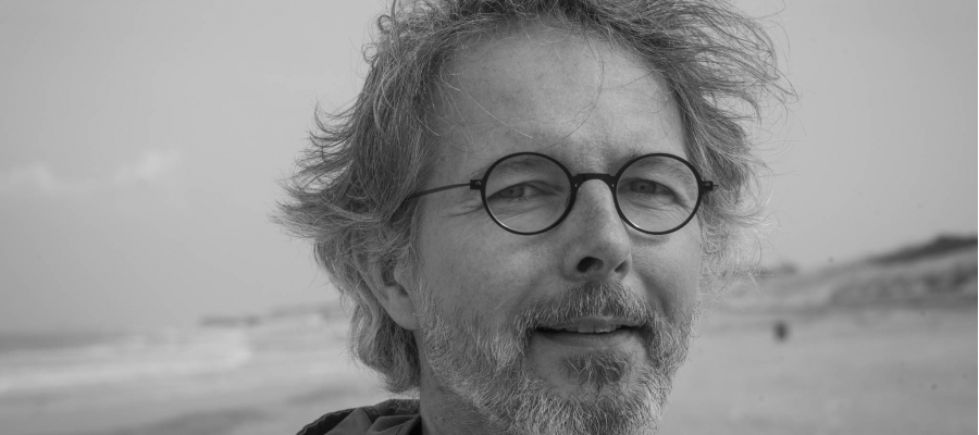 dichter Christophe Batens gefotografeerd op een strand