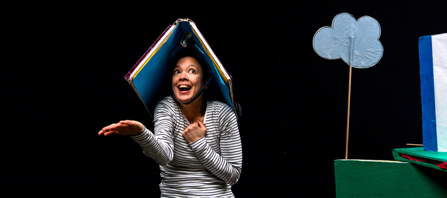 beeld uit de voostelling: vrouw met groot boek op haar hoofd