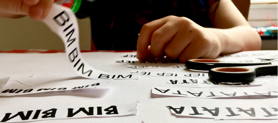 kinderhanden plakt papierstrookjes met woorden erop