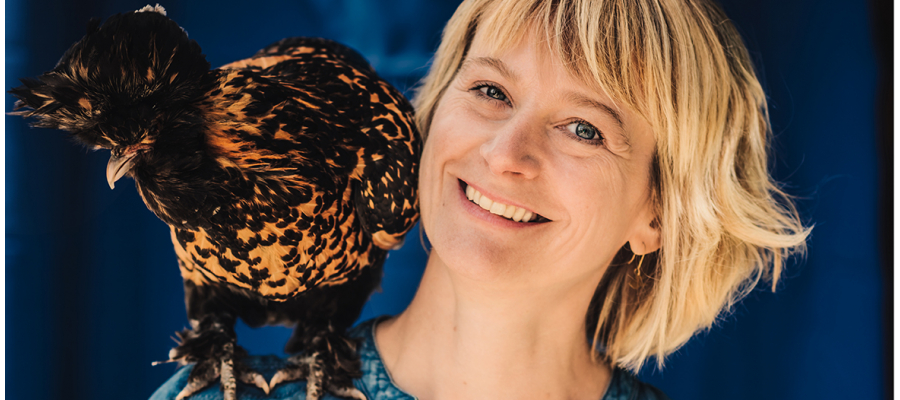 journaliste Tine Hens draagt een jeanshemd en een grote vogel op haar schouder
