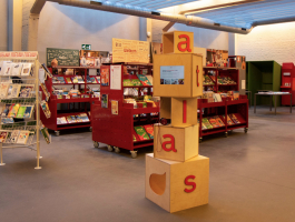 foto: een toren van houten kubussen met videoscherm staat opgesteld in de bibliotheek